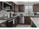 Well-equipped kitchen with stainless steel appliances, mosaic backsplash, sleek countertops, and dark wood cabinetry at 9628 Gull Lake Dr, Indianapolis, IN 46239
