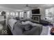 Cozy living room featuring hardwood floors, fireplace, large gray sectional sofa, and ample natural light at 9628 Gull Lake Dr, Indianapolis, IN 46239