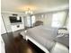 Main bedroom with dark hardwood floors, a crib, a decorative ceiling light, and an en suite bathroom at 9628 Gull Lake Dr, Indianapolis, IN 46239