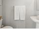 Bathroom showcases a toilet, pedestal sink, framed art, and decorative white textured towels at 9855 Oakmont E E Dr, Pendleton, IN 46064