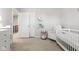 Comfortable Bedroom features white crib, plush chair, decorative books and soft carpet at 9855 Oakmont E E Dr, Pendleton, IN 46064