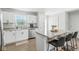 Bright kitchen equipped with white cabinets, stainless steel appliances, and an island with barstools at 9855 Oakmont E E Dr, Pendleton, IN 46064