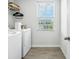 Functional laundry room is equipped with appliances, shelving, storage, and a bright window at 9855 Oakmont E E Dr, Pendleton, IN 46064