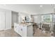 Open-concept living area features bar seating with kitchen island, neutral decor, wood-look flooring, and lots of natural light at 9855 Oakmont E E Dr, Pendleton, IN 46064