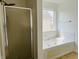 Bathroom featuring shower and soaking tub with tile surround and natural light at 9987 Rainbow Falls Ln, Fishers, IN 46037