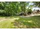 Grassy backyard with a fire pit, stacked wood, and a line of mature trees at 10519 N Antioch Rd, Mooresville, IN 46158