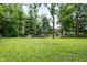 Lush backyard featuring an open grassy area, mature trees, and a fire pit at 10519 N Antioch Rd, Mooresville, IN 46158