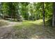 Spacious grassy backyard with a fire pit, mature trees, and wooden features at 10519 N Antioch Rd, Mooresville, IN 46158