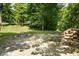 Backyard with a fire pit, stacked logs, surrounded by a beautiful tree line at 10519 N Antioch Rd, Mooresville, IN 46158