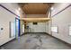 Unfinished garage interior with a blue door, overhead lighting, and elevated platform at 10519 N Antioch Rd, Mooresville, IN 46158