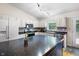 Well-lit kitchen with white cabinets, dark countertops, and a blue kitchen island at 10519 N Antioch Rd, Mooresville, IN 46158