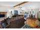 Open living room with a fireplace and wood beam ceilings, seamlessly connects to the kitchen at 10519 N Antioch Rd, Mooresville, IN 46158