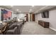 Finished basement with a gray couch, tv, mounted flag, and workout equipment at 110 Bow Ln, Indianapolis, IN 46220