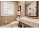 Charming powder room featuring a white vanity sink, classic fixtures, and a well-lit window at 110 Bow Ln, Indianapolis, IN 46220