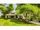 Beautiful home featuring a well-kept lawn, vibrant flower beds, and shade trees providing a peaceful setting at 110 Bow Ln, Indianapolis, IN 46220