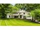 Elegant home with manicured lawn, lush landscaping, and a charming front entrance framed by mature trees at 110 Bow Ln, Indianapolis, IN 46220