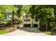 Spacious two-car garage with ample parking, framed by a lush green lawn and mature trees for privacy at 110 Bow Ln, Indianapolis, IN 46220