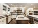 Gourmet kitchen with stainless steel appliances, marble counters, and adjacent breakfast and living room at 110 Bow Ln, Indianapolis, IN 46220