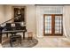 Bright living room with black baby grand piano, portrait, and French doors leading to backyard at 110 Bow Ln, Indianapolis, IN 46220
