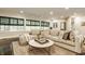 Bright living room with large windows, neutral-toned sectional sofa, and a round coffee table on a patterned rug at 110 Bow Ln, Indianapolis, IN 46220