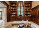 Stately office with custom wood bookshelves, bench seat, natural light, and view of the yard at 110 Bow Ln, Indianapolis, IN 46220