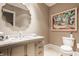 Stylish powder room with marble countertop vanity, decorative mirror, and modern commode at 110 Bow Ln, Indianapolis, IN 46220
