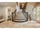 Elegant staircase with wrought iron railings, tile flooring, and artful decor showcasing sophisticated charm at 110 Bow Ln, Indianapolis, IN 46220