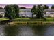 A well-maintained backyard with a wooden fence, overlooking a peaceful pond at twilight at 11820 Stepping Stone Dr, Fishers, IN 46037