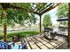 Outdoor grill and seating area with a pergola overlooking the pond and grassy yard at 11820 Stepping Stone Dr, Fishers, IN 46037