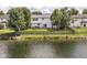A well-maintained backyard with a wooden fence, overlooking a peaceful pond on a sunny day at 11820 Stepping Stone Dr, Fishers, IN 46037