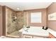 Elegant bathroom featuring a glass-enclosed shower and a luxurious soaking tub at 11820 Stepping Stone Dr, Fishers, IN 46037