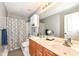 Well-lit bathroom featuring double sink vanity with wood cabinets and a shower/tub combo with decorative curtain at 11820 Stepping Stone Dr, Fishers, IN 46037