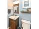 Cozy powder room features a modern vanity, toilet, decor and blue walls at 11820 Stepping Stone Dr, Fishers, IN 46037