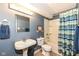 Well-lit bathroom featuring traditional sink and toilet plus tub/shower combo with blue striped shower curtain at 11820 Stepping Stone Dr, Fishers, IN 46037