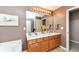 Bathroom featuring a double sink vanity with wood cabinets, a large mirror, and neutral decor at 11820 Stepping Stone Dr, Fishers, IN 46037