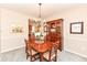 Traditional dining room with wooden furniture set, a chandelier, and views into the kitchen at 11820 Stepping Stone Dr, Fishers, IN 46037