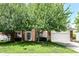 Charming brick home with a two-car garage and mature trees in a well-kept lawn and blue skies overhead at 11820 Stepping Stone Dr, Fishers, IN 46037