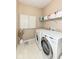 Functional laundry room features a washer and dryer, storage shelves, and ample room for laundry at 11820 Stepping Stone Dr, Fishers, IN 46037