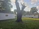 Exterior view of the backyard, showing mature tree, lawn, and white-sided home and garage at 1201 E Gimber St, Indianapolis, IN 46203