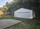 A view of the detached garage, showcasing its white siding, garage doors and fenced entrance at 1201 E Gimber St, Indianapolis, IN 46203