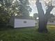 View of the home's detached white garage; a mature tree adds shade to the exterior at 1201 E Gimber St, Indianapolis, IN 46203