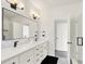 Bright bathroom featuring double vanity, black fixtures, herringbone backsplash, and a glass-enclosed shower at 1405 E Vermont St, Indianapolis, IN 46201