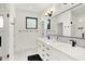 Modern bathroom with double vanity, black hardware, and a window providing natural light in the shower area at 1405 E Vermont St, Indianapolis, IN 46201