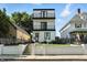 Modern three-story home with white siding, black trim, and a double-balcony facade offers stylish curb appeal at 1405 E Vermont St, Indianapolis, IN 46201