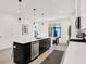 Bright kitchen featuring a kitchen island, stainless steel appliances, white cabinets, and modern pendant lighting at 1405 E Vermont St, Indianapolis, IN 46201