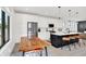 Modern kitchen with white cabinets, stainless steel appliances, kitchen island with seating, and dining table at 1405 E Vermont St, Indianapolis, IN 46201