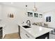 Modern kitchen features white cabinets, stainless sink, and view to the living room at 1405 E Vermont St, Indianapolis, IN 46201
