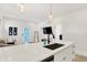 Modern kitchen features stainless sink, white cabinets and view to the living room and back door at 1405 E Vermont St, Indianapolis, IN 46201
