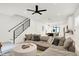 Open-concept living room showcasing a large gray couch, staircase and modern finishes offers a relaxed atmosphere at 1405 E Vermont St, Indianapolis, IN 46201