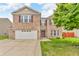 Charming two-story brick home with a well-maintained lawn, attached two car garage and inviting entryway at 1449 Danielle Dr, Indianapolis, IN 46231